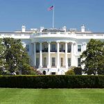 White House with American flag and green lawn