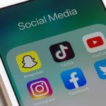 Phone showing social media app icons Snapchat TikTok YouTube