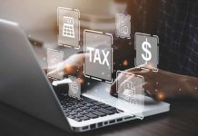 Person typing on laptop with tax-related icons displayed