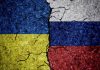 Cracked Ukrainian and Russian flags painted on concrete