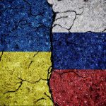 Cracked Ukrainian and Russian flags painted on concrete