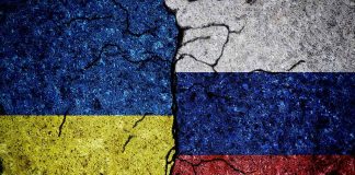 Cracked Ukrainian and Russian flags painted on concrete