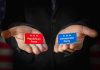 Hands holding Republican and Democratic Party cards