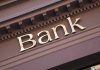 Gold bank sign on building facade