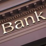 Gold bank sign on building facade