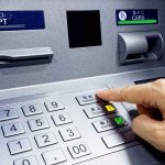 Person pressing button on an ATM keypad.
