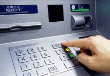 Person pressing button on an ATM keypad.