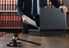 Gavel and person opening briefcase in law office
