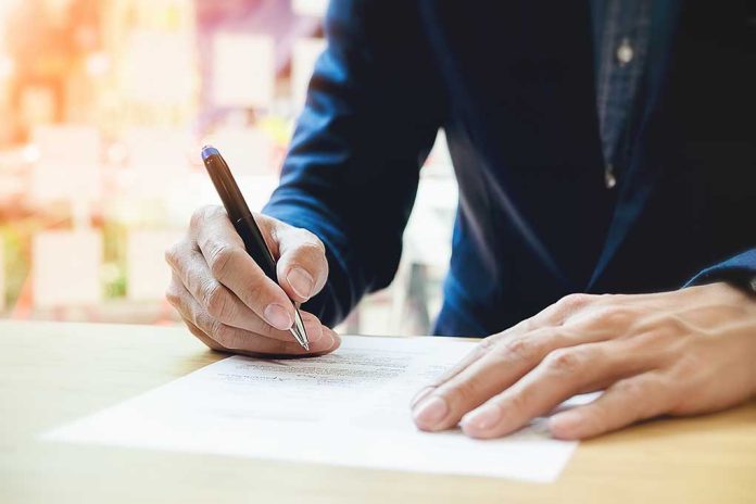 613375877 featured image Person signing a document with a pen.