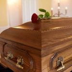 Wooden coffin with red rose on top