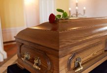 Wooden coffin with red rose on top