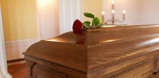 Wooden coffin with red rose on top
