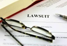 Lawsuit document with glasses pen and book
