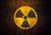Yellow radiation warning symbol on rusty metal surface