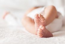 Close-up of baby feet lying on blanket