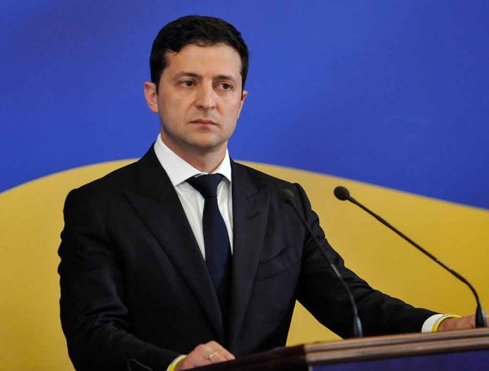 1448861675 featured image Man in suit speaking at podium with microphones