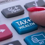 Finger pressing calculator tax and wealth button