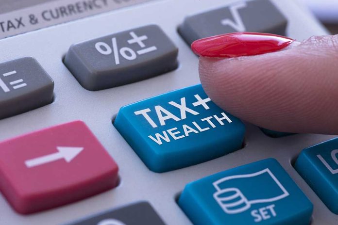 1762066592 featured image Finger pressing calculator tax and wealth button