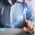 Person pointing at an upward trend line graph