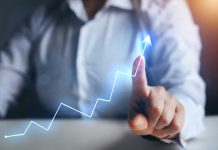 Person pointing at an upward trend line graph