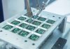 Robotic arm assembling electronic circuit boards in production