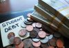 Note with student debt coins and banknotes
