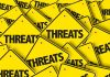 Yellow warning signs with the word THREATS