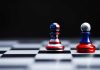 Two chess pawns painted as American and Russian flags