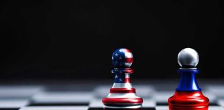 Two chess pawns painted as American and Russian flags