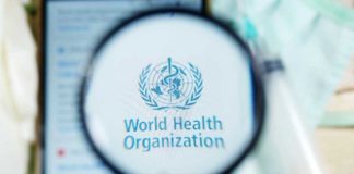 Magnifying glass focused on World Health Organization logo