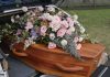 Coffin with flowers in the back of a hearse