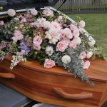 Coffin with flowers in the back of a hearse