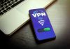 Smartphone displaying VPN app beside a laptop