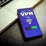 Smartphone displaying VPN app beside a laptop