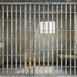 Empty rusty prison cell with a small window