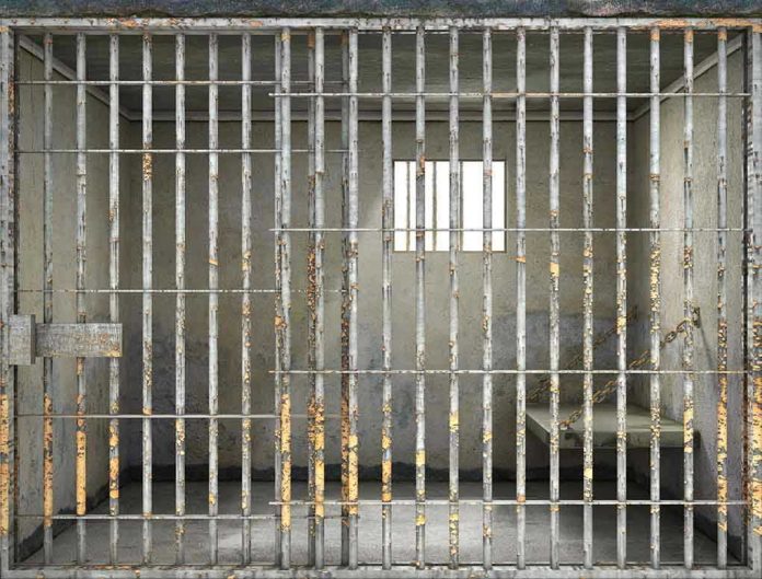 508424233 Empty rusty prison cell with a small window