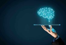 Hand holding tablet projecting digital brain hologram