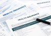 Close up of health insurance application forms with a pen