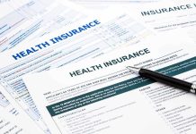 Close up of health insurance application forms with a pen