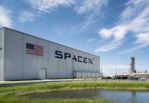 SpaceX building with American flag and launch pad