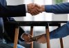 Handshake and exchange of money under the table.