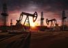 Oil rigs operating at sunset in a desert landscape