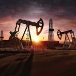 Oil rigs operating at sunset in a desert landscape