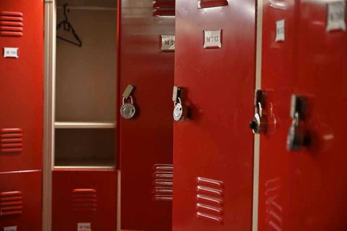 1862930638 Red lockers with padlocks, one open with hanger.