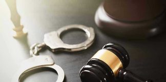 Handcuffs and judge's gavel on the table