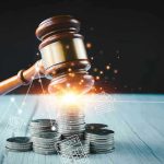 Gavel, coins, and tax icons on a table.