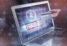 Person holding credit card near laptop displaying fraud