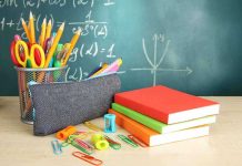 A collection of school supplies including notebooks, a pencil case, and writing instruments on a desk
