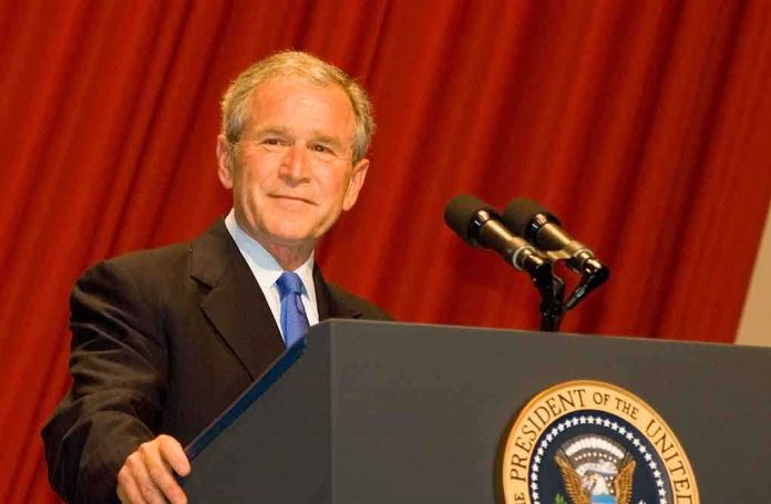 shutterstock_50298856.jpg A man in a suit standing at a podium with microphones and a presidential seal