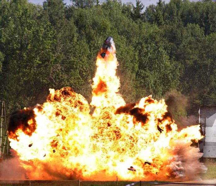 A large explosion with flames and smoke in an outdoor setting